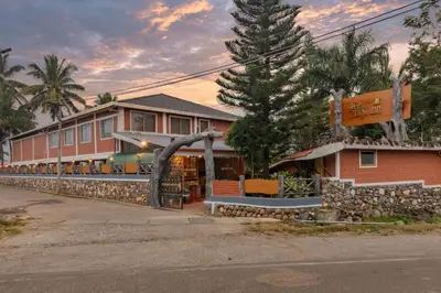 a building with a sign on the side of a street at The Nest Inn Resort in Masinagudi