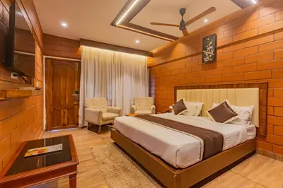 a hotel room with a bed and a tv at The Nest Inn Resort in Masinagudi