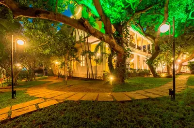 a building with a tree and a sidewalk at Royal Orchid Metropole Mysore in Mysore