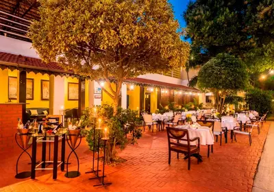 a restaurant with tables and chairs on a brick patio at Royal Orchid Metropole Mysore in Mysore