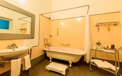 a bathroom with a tub and a sink and a mirror at Royal Orchid Metropole Mysore in Mysore