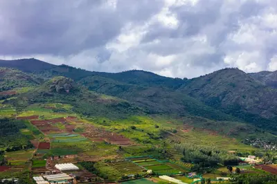 an aerial view of a mountain with a town on it at Teanest Nightingale by Nature Resorts and Stays in Kotagiri