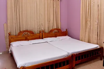 two twin beds in a room with purple walls at Krishnendu Homestay outer ring road north nada guruvayur in Guruvāyūr
