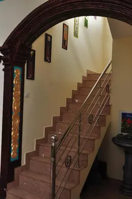 a stairway in a home with a wooden stair case at Krishnendu Homestay outer ring road north nada guruvayur in Guruvāyūr