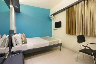 a bedroom with a bed and a blue wall at Mannars Deluxe Lodge in Mysore