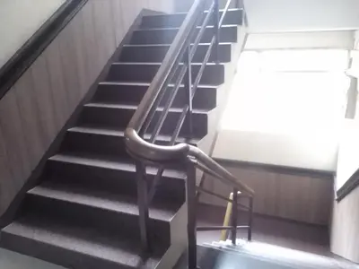 a staircase in a building with a metal railing at Hotel Preethi Palace in Ooty
