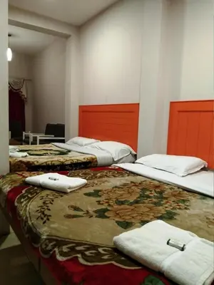 a room with three beds with towels on them at Hotel Preethi Palace in Ooty