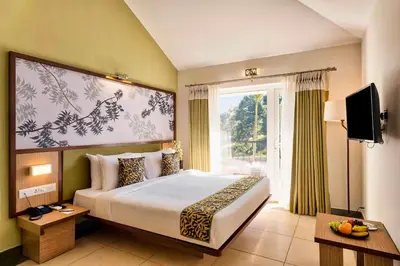a bedroom with a large bed and a window at Sterling Wayanad in Sultan Bathery