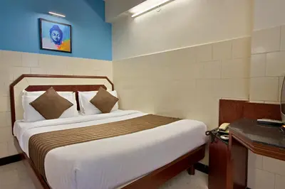 a bedroom with a bed and a desk in a room at Mannars Yatri Nivas Hotel in Mysore