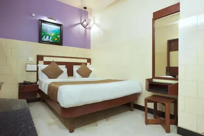 a bedroom with a large bed and a mirror at Mannars Yatri Nivas Hotel in Mysore