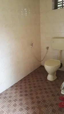 a bathroom with a toilet in a tiled room at Wayanad Homestay in Kalpetta