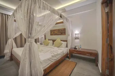 a bedroom with a bed with a mosquito net at Elixir Hills Suites Resort and Spa in Munnar