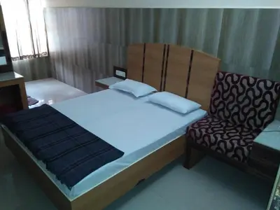 a bedroom with a bed and a chair at SOUTH SIDE RESIDENCY By Chungath in Kizhake Chālakudi