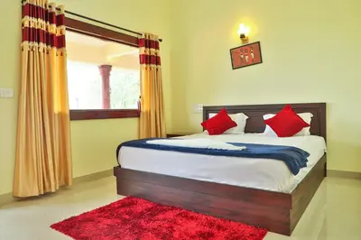 a bedroom with a bed with red pillows and a red rug at Green Garden Deluxe Room in Vayittiri