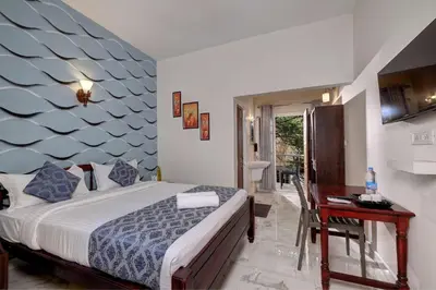 a bedroom with a bed and a table and a desk at Kurinji Wanderlust Resort Munnar in Munnar