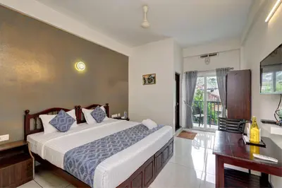 a bedroom with a large bed and a desk at Kurinji Wanderlust Resort Munnar in Munnar