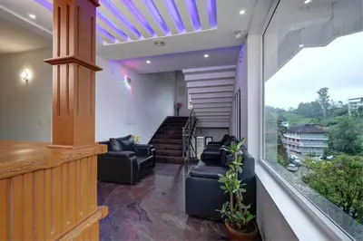 a living room with couches and a balcony at Kurinji Wanderlust Resort Munnar in Munnar