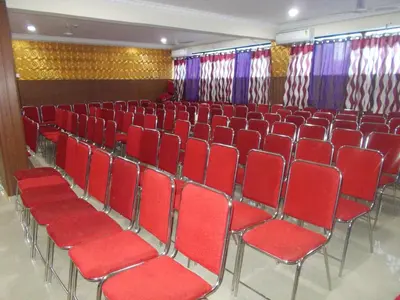 a theater with red chairs in a room with curtains at Avanti Inn in Guruvāyūr