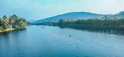 a person in a boat on a river at Windermere River House in Neriyamangalam