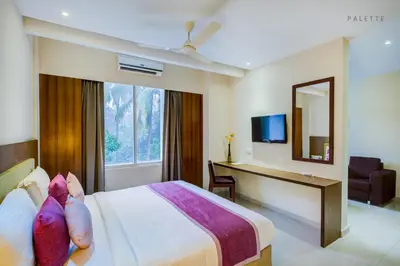 a hotel room with a bed and a desk and a mirror at JK Residency Kelakam in Kelakam
