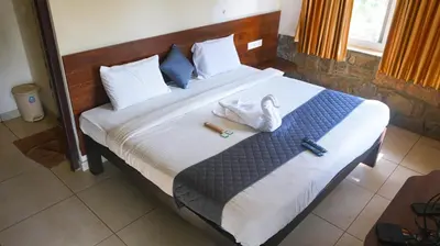 a bedroom with a bed with towels on it at River Valley Resort in Masinagudi