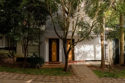 a white house with a door in the middle of trees at Casa Rio Resorts Athirappilly in Athirappilly