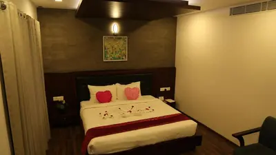 a hotel room with a bed with red pillows at Four N Square Residency in Palakkad