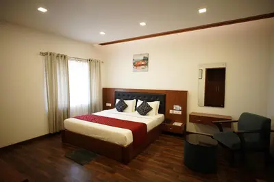 a hotel room with a bed and a chair at Four N Square Residency in Palakkad
