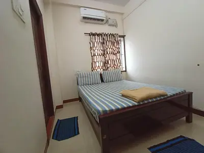 a small bed in a room with a window at Aditya Residency in Pollāchi
