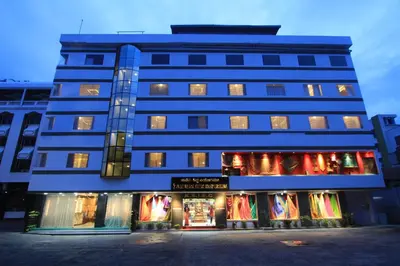 a blue building with a store in front of it at Sandesh Pride in Mysore