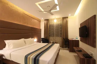 a hotel room with a bed and a television at Sandesh Pride in Mysore