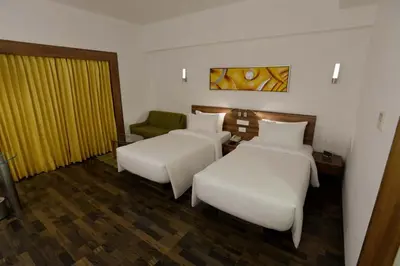 a hotel room with two beds and a couch at Lemon Tree Hotel Coimbatore in Coimbatore