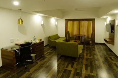 a living room with a couch and a table at Lemon Tree Hotel Coimbatore in Coimbatore