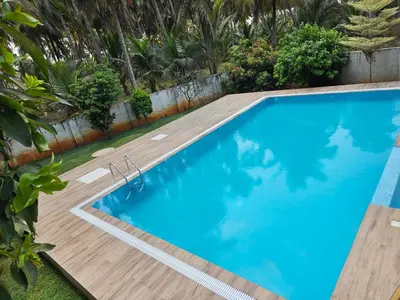 an image of a swimming pool with a wooden deck at Hotel Gopalapuram International in Pollāchi