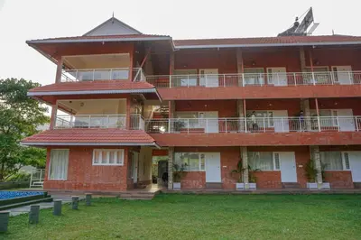 a large red brick building with a lawn in front of it at Willow Heights in Athirappilly