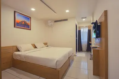 a bedroom with a bed and a television in it at SAAS Residency in Kozhikode