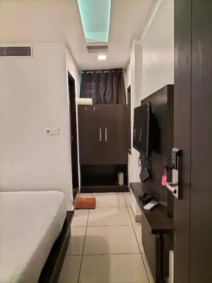 a bedroom with a bed and a tv in a room at SAAS Residency in Kozhikode