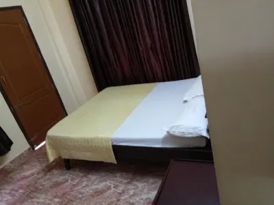 a bed in a hotel room with at Anandkrishna Residency in Guruvāyūr
