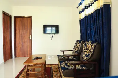 a room with two chairs and a table and a door at Green Garden Wayanad Villas in Vayittiri