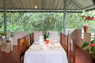 a table with a white tablecloth and chairs in at Royal Woods Coorg in Madikeri