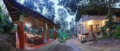 an exterior view of a house with tables and chairs at Royal Woods Coorg in Madikeri