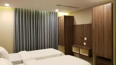 a hotel room with two beds and a window at U C plaza in Perintalmanna