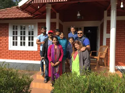 a group of people standing on the porch of a house at Marsim Holiday Resort in Vythiri