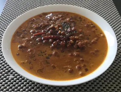 a bowl of chili with beans and chili sauce at ExoticaHolidays in Sultan Bathery