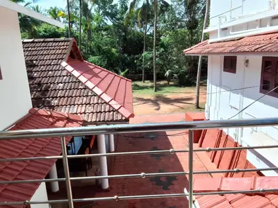 a view from the balcony of a house with a red roof at Liberty House - SeaView in Kozhikode