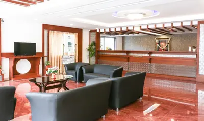 a waiting room with chairs and a table and a tv at Treebo Premium Akshaya Mahal Inn in Mysore