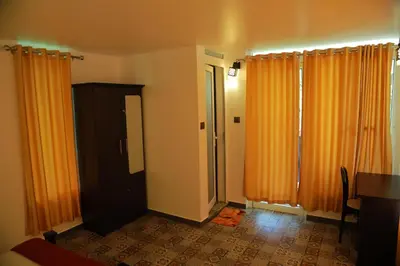 an empty room with orange curtains and a door at Lakefront Beach Homes in Cherai Beach