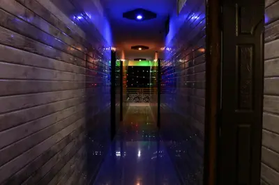 an empty hallway with blue lights on the wall at Sri Priya Lodge in Dharmapuri