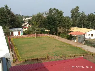 a view of a yard with a large lawn at Singaras Coffee Country in Masinagudi