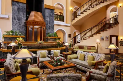 a lobby with couches and tables and a staircase at Fortune Resort Sullivan Court, Ooty - Member ITC Hotels' Group in Ooty